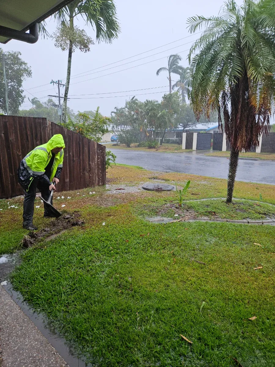 Robert Keegan clearing drainage in heavy rain during a severe weather response in Cairns